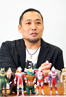 飯塚航也氏　ウルトラヒーローと怪獣フィギュアを前に